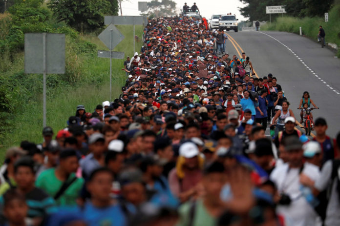 Migrants, part of a caravan traveling from Central America en route to the United States walk by the road that links Ciudad Hidalgo with Tapachula
